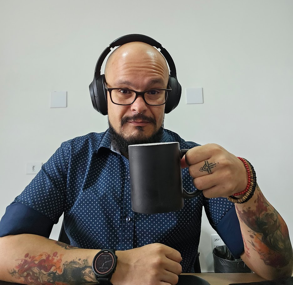 Fábio à mesa, de fones de ouvido e com uma caneca