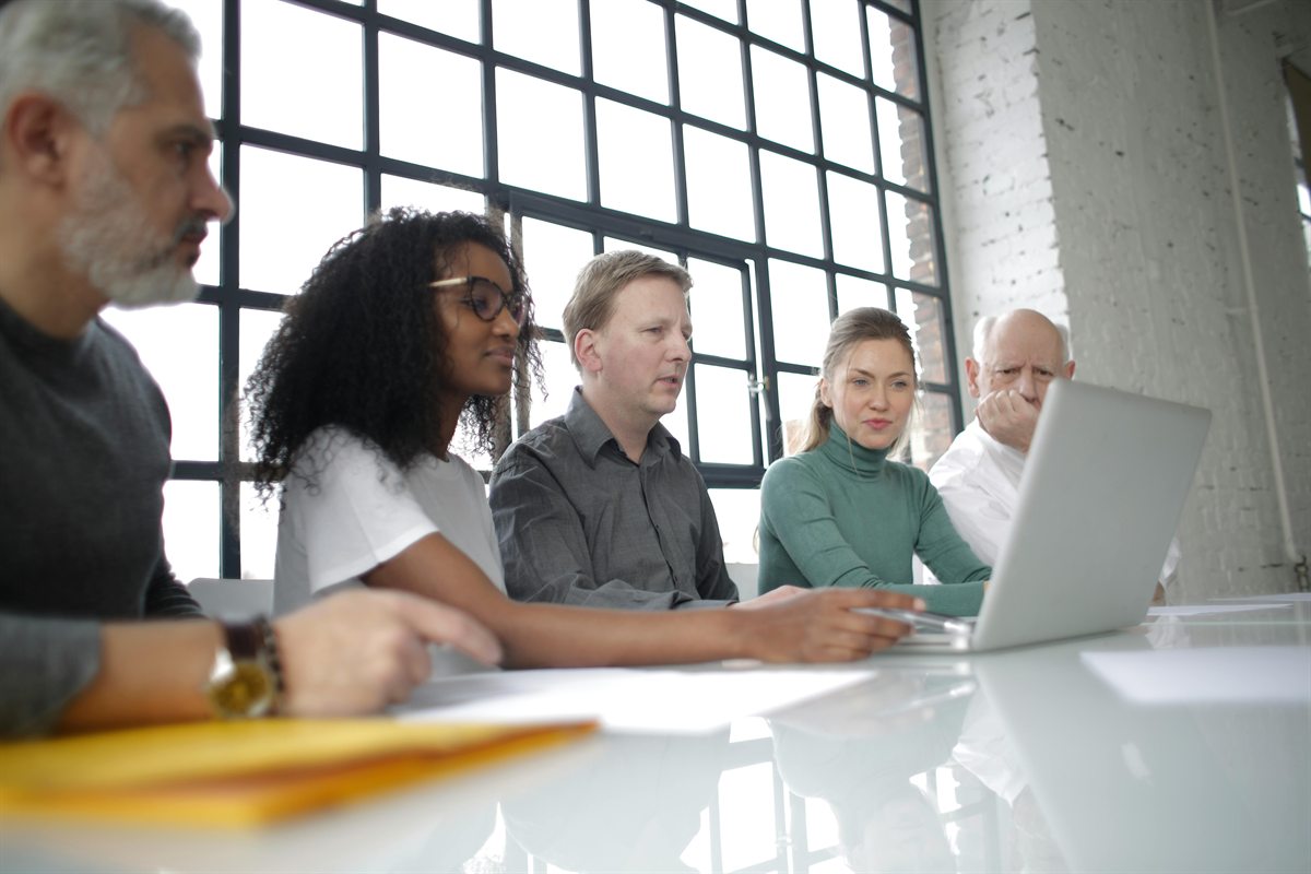Equipe diversa analisando um projeto em um notebook